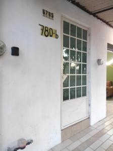 a white house with a door and a sign on it at Departamento Privado in Guadalajara