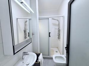 a white bathroom with a sink and a toilet at Easyhome in Brazzaville +60 photos