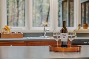 a bottle of wine sitting on a counter with two glasses at Black Forest - Wifi, Pet Friendly, Grill, Deck, Screen Porch, Family Friendly, Fireplace, Pool Access, Hiking in Berkeley Springs