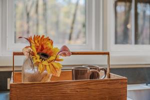 a wooden box with two cups and a flower in it at Black Forest - Wifi, Pet Friendly, Grill, Deck, Screen Porch, Family Friendly, Fireplace, Pool Access, Hiking in Berkeley Springs