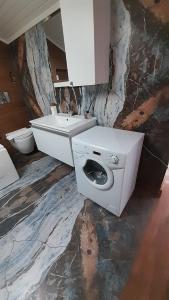 a white bathroom with a sink and a toilet at BAT Apart Otel in Antalya