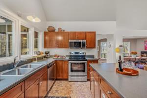 a kitchen with wooden cabinets and stainless steel appliances at Black Forest - Wifi, Pet Friendly, Grill, Deck, Screen Porch, Family Friendly, Fireplace, Pool Access, Hiking in Berkeley Springs
