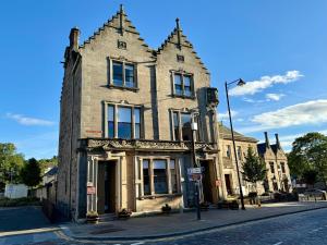 an old building on the corner of a street at Linen Bank Residence - Aparthotel in Linlithgow