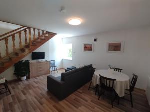 a living room with a table and a couch at Tiszafa Apartman in Csopak