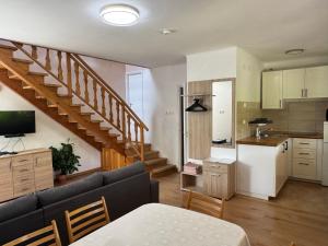 a living room with a couch and a kitchen at Tiszafa Apartman in Csopak