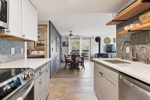 a kitchen with white cabinets and a dining room at The Summit at Mountainside in Stowe