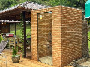 a brick enclosure with a glass door on a patio at Estação Serramar in Lumiar