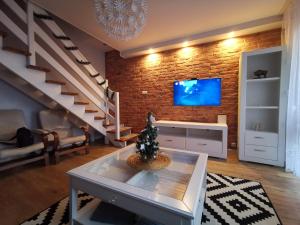 a living room with a tv and a brick wall at Dwa poziomy Wrocławska in Białystok