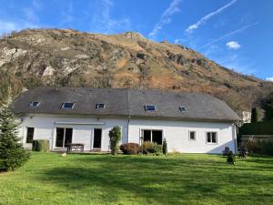 a white house with a mountain in the background at Lo Saunei in Laruns