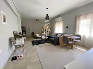 a living room with a couch and a table and chairs at Xrysa's Central City Apartment in Missolonghi