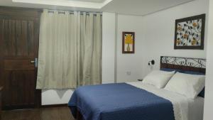 a bedroom with a blue bed and a window at Central Apartment 2 in Ouro Preto