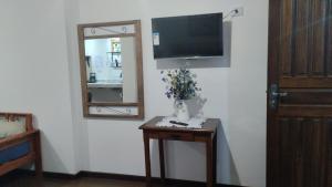 a room with a television and a table with a mirror at Central Apartment 2 in Ouro Preto