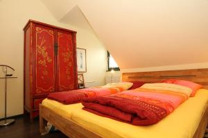 a bedroom with two beds and a red cabinet at Ferienwohnanlage Alte Molkerei in Rankwitz