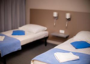 a hotel room with two beds with blue pillows at Stara Owczarnia NOWA NIEDRZWICA in Nowa Niedrzwica