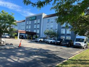 a hotel with cars parked in front of a parking lot at Quality Inn & Suites CVG Airport in Erlanger