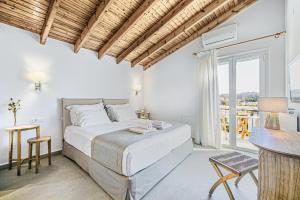 un dormitorio blanco con una cama y un balcón en Villa Eftichia Hotel Apartments & Studios, en Kontokali 82 fotos más