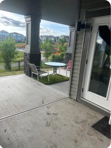 a patio with a table and a chair on a porch at Pond view Walkout in Airdrie
