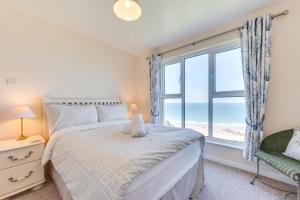 a bedroom with a bed and a window with the ocean at 3 Bed in Putsborough oc-flat11 in Croyde +12 photos