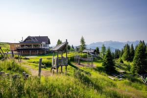 ein Haus auf einem Hügel mit einem Spielplatz in der Unterkunft Hotel Marko in Nötsch