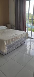 a bed sitting in a room with a window at Casa da Lelê in Acaraú