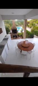 a patio with a table and chairs and a grill at Casa da Lelê in Acaraú