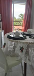 a table with a white table cloth on a chair at Casa da Lelê in Acaraú