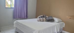 a bedroom with a white bed with towels on it at Casa da Lelê in Acaraú