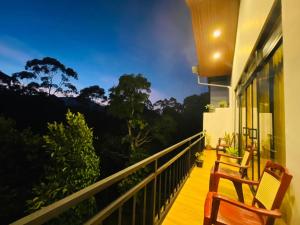 a balcony with chairs and a view of the forest at Ella White Tea Garden Hotel in Ella