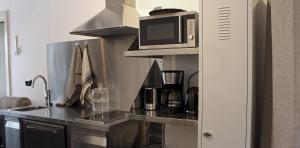 a kitchen with a counter top with a microwave at Het Verborgen Jagershuisje in Wedde +10 photos