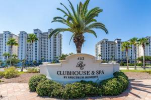 a sign with a palm tree in front of a building at Beach Club 806A by Youngs Suncoast in Gulf Highlands