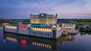 a hotel building with lights on the water at night at Isle Casino Hotel Waterloo Hotel & Casino - A Caesars Rewards Destination in Waterloo