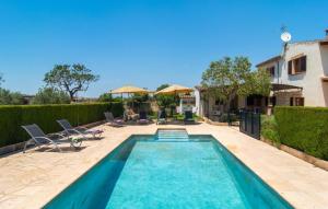 a swimming pool with chairs and a house at Es Cipres in Porreres