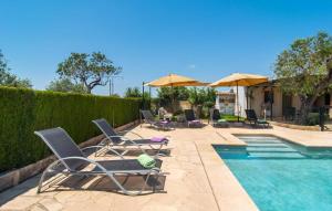 a group of chairs and umbrellas next to a swimming pool at Es Cipres in Porreres +54 photos