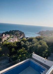 a swimming pool on top of a house with the ocean at Rozana Rooms in Ulcinj