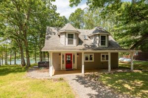 a small house with a red door in a yard at Smooth Sailing by Railey Vacations in Swanton