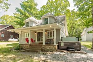 a small white house with two red chairs on the porch at Smooth Sailing by Railey Vacations in Swanton