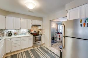 a kitchen with white cabinets and a stainless steel refrigerator at Woodsy & Charming! Applegate Cabin w/ Large Yard in Applegate +18 photos