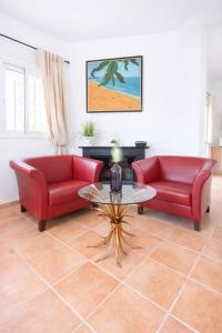 a living room with two red couches and a table at Finca Feliciano in Novo Sancti Petri