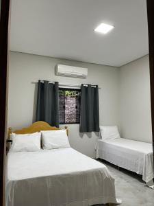 a room with two beds and a window at CasAnita in Cavalcante