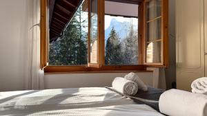 a bedroom with a bed and a window with a view at Peacefull Mountains View in Kandersteg