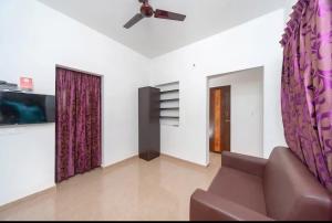 a living room with a couch and a ceiling fan at Varun Residency New in Coimbatore