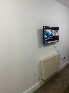 a flat screen tv hanging on a white wall at Comfy private studio Moseley in Birmingham