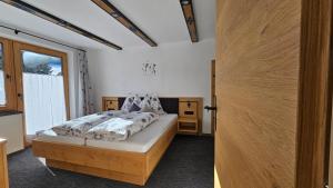 a bedroom with a bed and a large window at Haus Enzian Apartments in Kartitsch