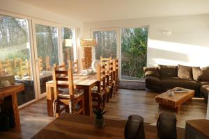 a living room with a table and chairs and a couch at Ferienhaus TRAUM AM SEE mit Sauna und Whirlpool in Zislow
