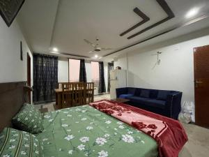 a bedroom with a bed and a blue couch at Own It Hotel in Islamabad