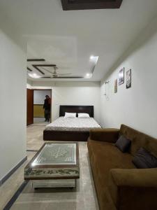 a living room with a bed and a couch at Own It Hotel in Islamabad +31 photos
