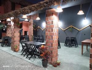 a dining room with a table and chairs and lights at Pousada Portal D'amaro in Santo Amaro