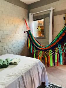 a bedroom with a bed with a colorful blanket at Pousada Portal D'amaro in Santo Amaro