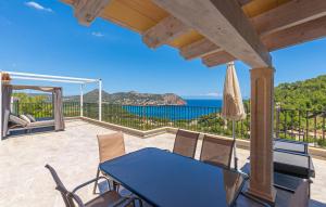 a patio with a blue table and chairs and the ocean at Cap Vermell in Canyamel