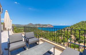 a balcony with two chairs and a view of the ocean at Cap Vermell in Canyamel